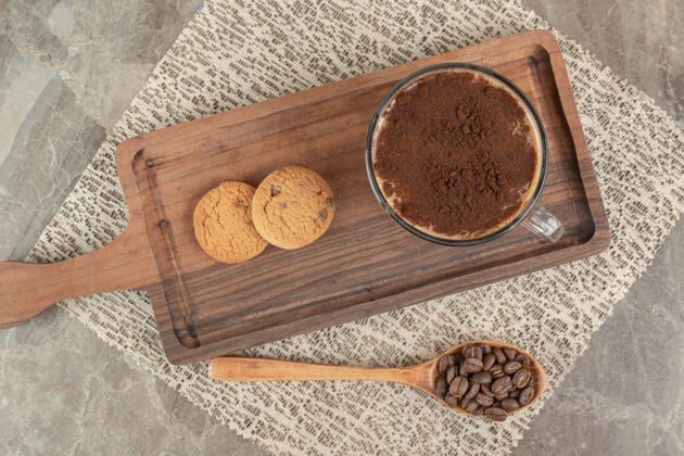木头一杯热咖啡 饼干放在木板上加咖啡豆勺子卡布奇诺
