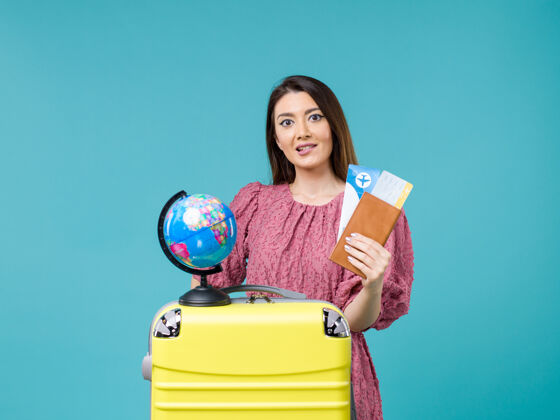 航程正面图度假中的女性拿着她的钱包和机票在蓝色的海底旅行度假女性旅行钱包假期旅行