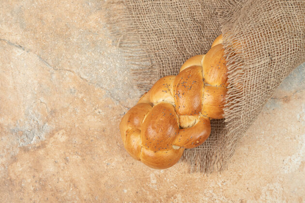 切割新鲜的白面包放在大理石表面的麻布上美味面包配料