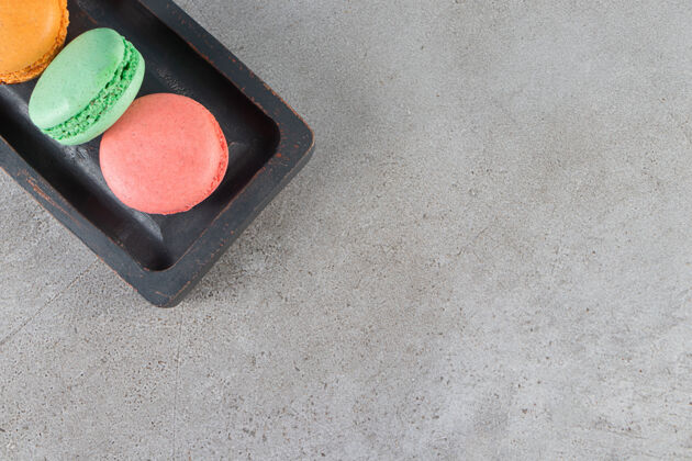 品种不同颜色的通心粉饼干放在深色木板里美味开心果堆栈