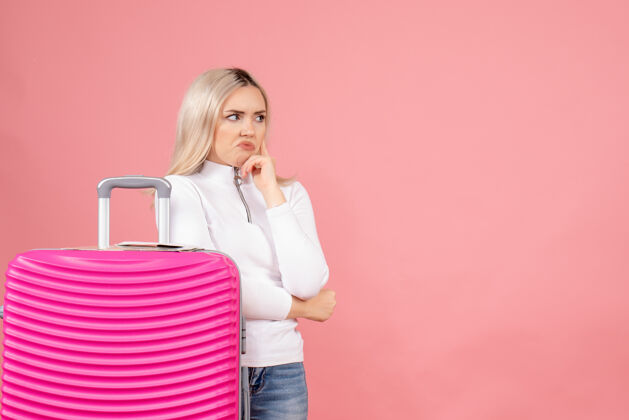 可爱正面图漂亮的女人拿着粉色的手提箱在想什么人快乐休闲