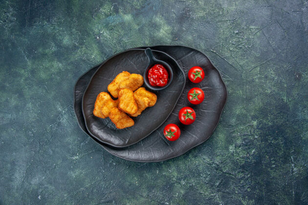煎锅黑色盘子里的鸡块和番茄酱番茄的俯视图平底锅晚餐番茄酱
