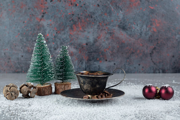 美味黑色咖啡杯 在大理石表面的椰子粉上装饰圣诞饰品美味食物节日