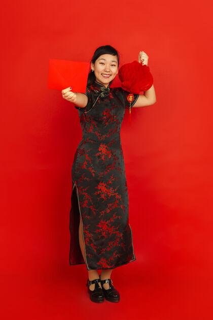 祝福2020年中国新年红色背景上的亚洲少女肖像穿着传统服装的女模特看起来很高兴装饰和红包庆祝 节日 情感青少年庆祝照明