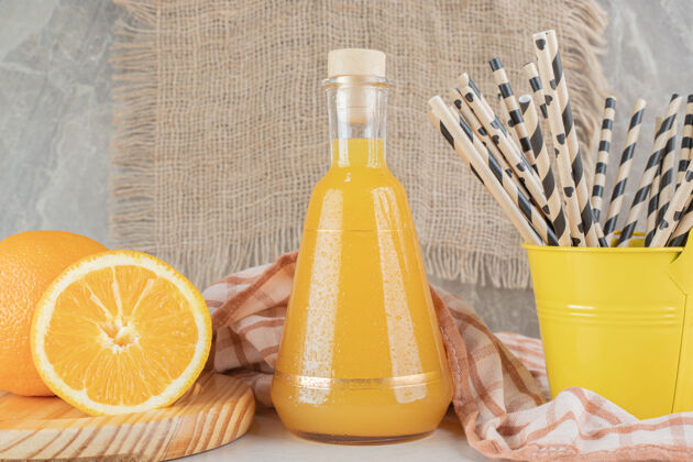 膳食一罐橙汁和新鲜的橙子放在大理石表面美味食物鸡尾酒