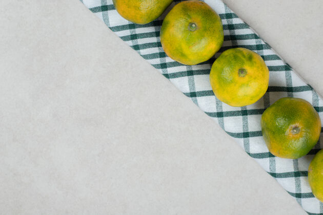 食品条纹桌布上的一束绿橘子新鲜营养膳食