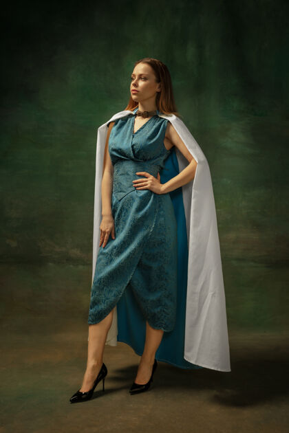 时代优雅的姿势在黑暗的背景下 中世纪年轻女子身着蓝色复古服装的肖像作为公爵夫人 皇室成员的女性模特时代 现代 时尚 美丽的比较概念好人历史