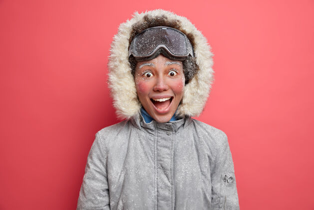 皮毛情绪开朗的冬日女孩表情喜出望外 满脸通红 满脸白霜 冬季滑雪时穿着暖和的夹克切断白霜满意