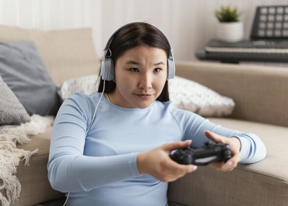 游戏带着耳机和控制器的女孩耳机设备控制器