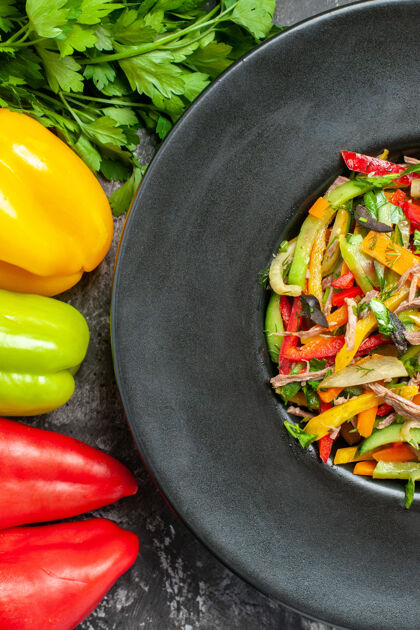 美味蔬菜沙拉黑色表面上美味蔬菜沙拉的俯视图胡椒健康素食