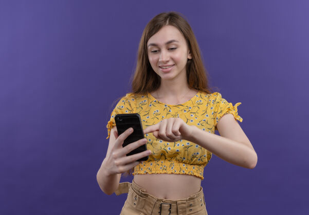 兴奋兴奋的年轻女孩拿着手机 把手指放在孤立的紫色空间与复制空间女孩年轻紫色