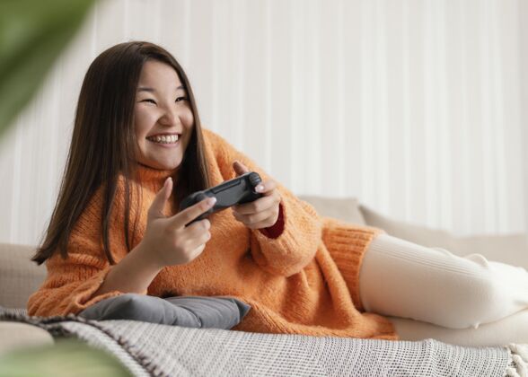 乐趣笑脸女孩玩电子游戏控制器中景视频游戏控制器