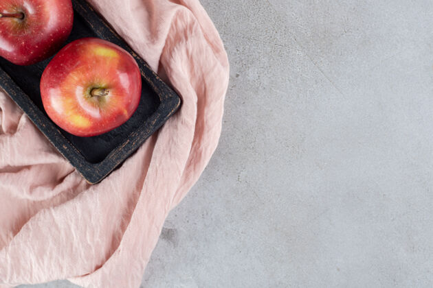 营养把新鲜的苹果放在水泥桌上的托盘上有机美味饮食