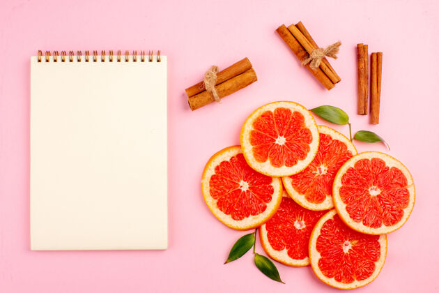 水果粉红色表面上美味的葡萄柚和多汁的水果片的俯视图新鲜新醇香