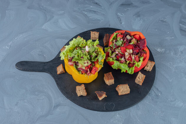 饮食把蔬菜沙拉分成甜椒片 放在大理石桌上的托盘上美味营养莴苣