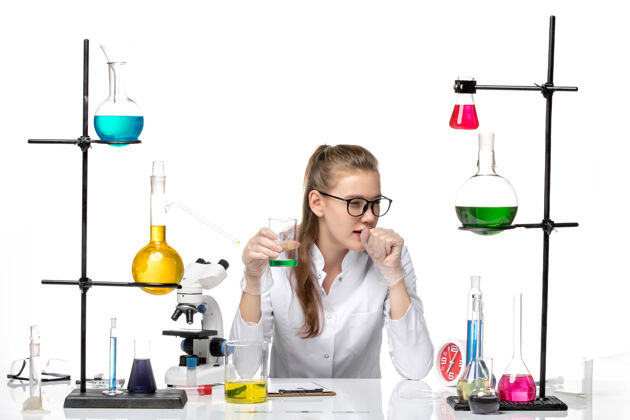女化学家前视图穿着医疗服的女化学家在白色背景上检查溶液的气味和咳嗽化学大流行健康病毒烧杯成人白人