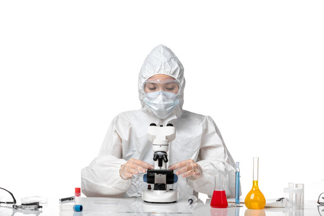 女医生正面图女医生穿着防护服 戴口罩 因柯维德使用显微镜对白色办公桌病毒大流行健康柯维德病毒实验室外套正面