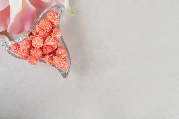 食欲大理石桌上马蹄莲花瓣旁的小三角碟零食自然糖果