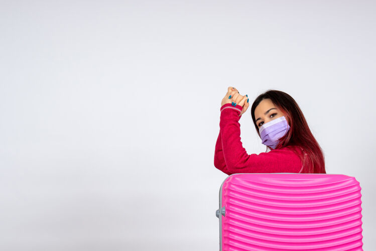 风景正面图白色墙壁上戴着粉红色面具的年轻女性度假用的是柯维病毒-大流行病毒的颜色颜色假期女人