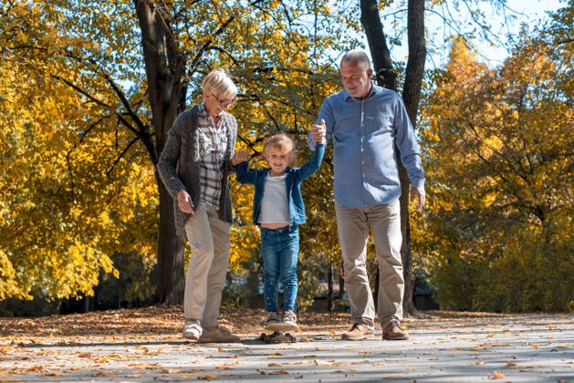 人快乐的爷爷奶奶和他们的孙子在公园里玩男人秋天女儿