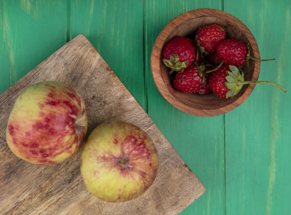 食物顶视图草莓在碗与苹果在砧板上碗草莓切
