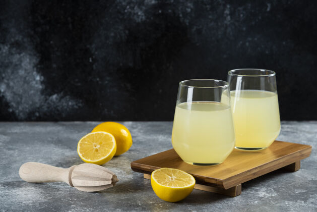 自制的杯子里装满了柠檬水 还有柠檬片和木铰刀凉的水冷的