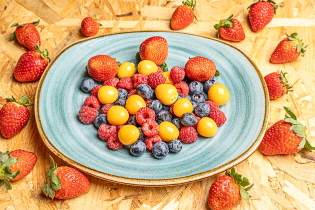 美味圆形白色盘子上新鲜浆果的俯视图夏季甜点蓝莓