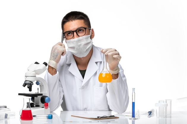 外套正面图：男医生 穿着白色医疗服 戴着面罩 在空白处工作实验室外套溶液药品