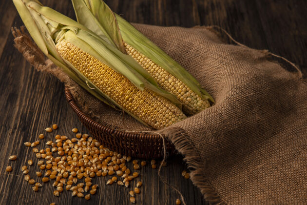 玉米有机新鲜玉米的俯视图 头发放在布袋桶上 玉米粒被隔离在木桌上桶果仁木材