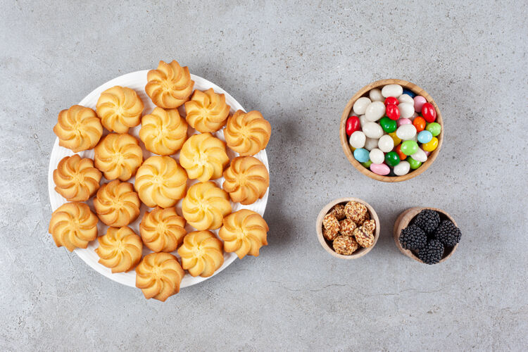 菜肴碗的桑葚 糖果和花生自制饼干放在大理石背景的盘子上高品质的照片饼干美味饼干