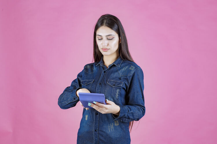 数学女孩手里拿着一个蓝色的计算器在计算姿势人财务