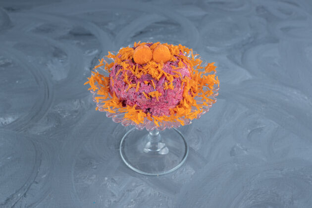 核桃用胡萝卜装饰的甜菜和胡桃沙拉 放在大理石表面的玻璃基座上沙拉台座可口
