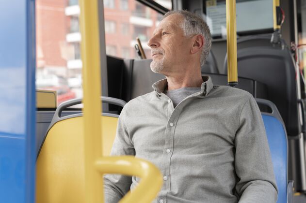 男性坐在公共汽车上的现代老人老年人城市男人