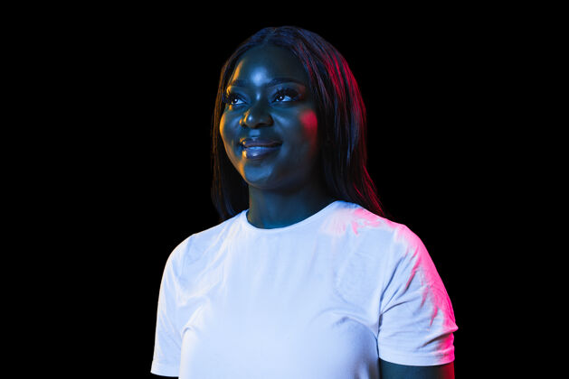 女人非洲年轻女性肖像在黑暗的霓虹灯墙壁人类情感的概念面部表情青年销售广告年轻模型兴奋