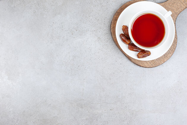 美味一杯茶放在一个茶碟上 在一块木板上 大理石背景上高质量的照片大枣茶碟新鲜