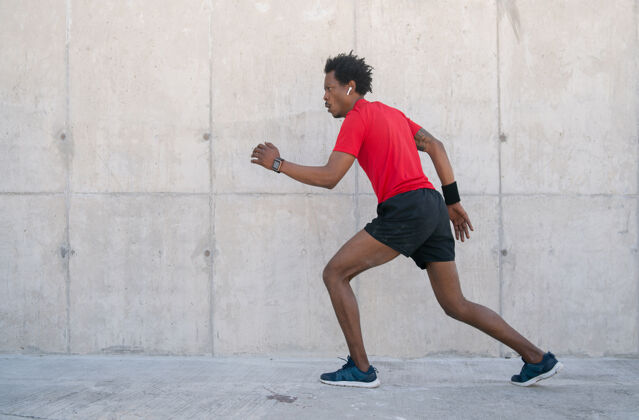耳塞一个黑人运动员在街上户外跑步锻炼运动服身体活跃