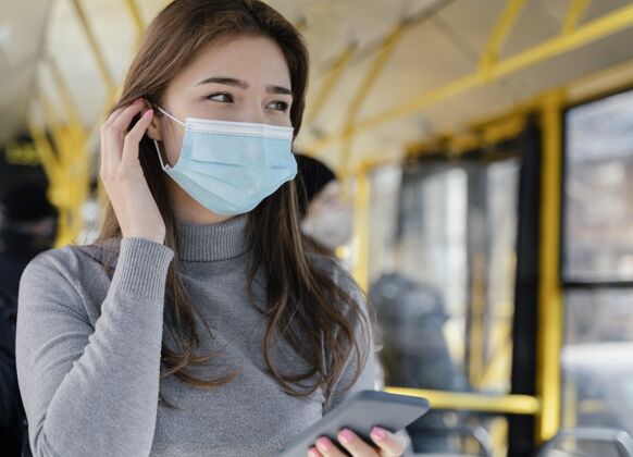 感染预防年轻女子乘坐城市巴士使用智能手机病毒旅游汽车
