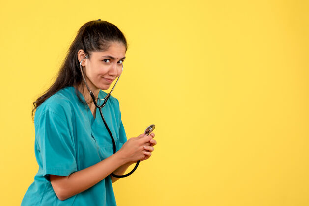 人前视图女医生用听诊器站着女人使用年轻