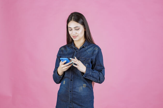 服装穿着牛仔衬衫的女孩在智能手机前聊天成人设备音频