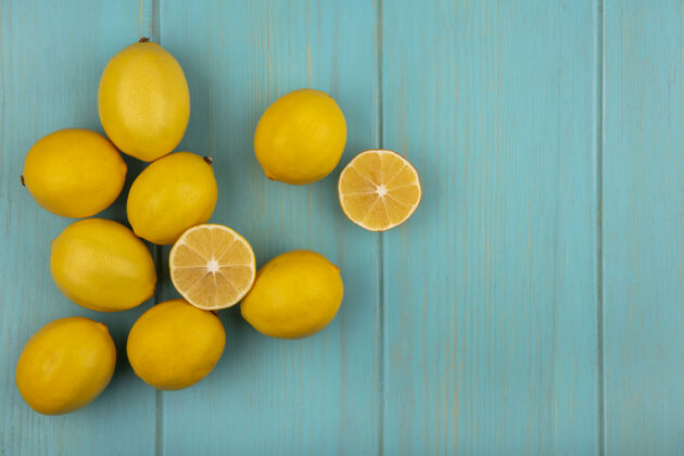 皮肤顶视图新鲜的黄色皮肤柠檬隔离在一个蓝色的木制背景与复制空间健康切片视图