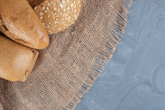 美味一捆面包放在大理石背景上的一块布料上风味早餐美味