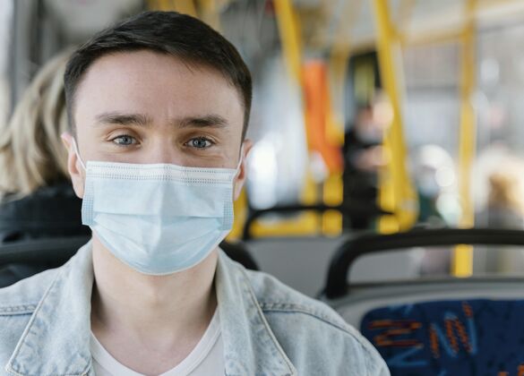 城市公共汽车年轻人戴着口罩坐公交车公共汽车病毒交通