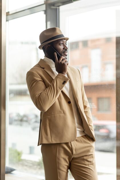 男士穿着米色西装的现代非洲裔美国人生活方式时尚室内