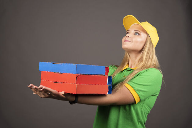 工艺穿着制服的女送货员拿着披萨的纸板高质量的照片纸箱工人盒子