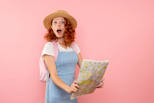 情感女游客正拿着地图在外国寻找方向美丽女人粉色
