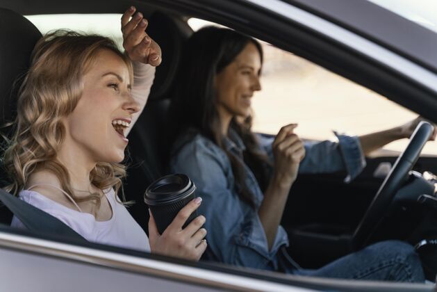 女人女孩们在车里玩得很开心成年人汽车车