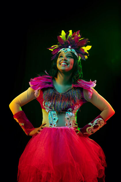 里约热内卢戴着嘉年华面具和化装舞会服装的美丽年轻女子在五颜六色的灯光下时尚巴西肖像