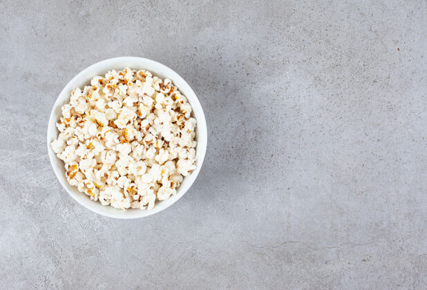 脆一碗松脆的爆米花在大理石背景上高质量的照片盐电影院脆