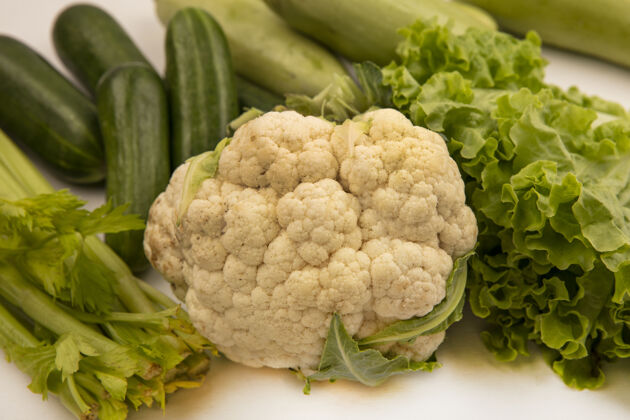 顶部白色背景上的美味蔬菜 如花椰菜 莴苣 芹菜 黄瓜和西葫芦的俯视图生菜健康白色