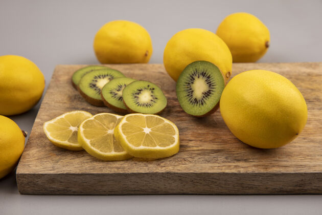 灰色新鲜的柠檬片和猕猴桃的俯视图被隔离在灰色背景的木制厨房板上健康柠檬景观